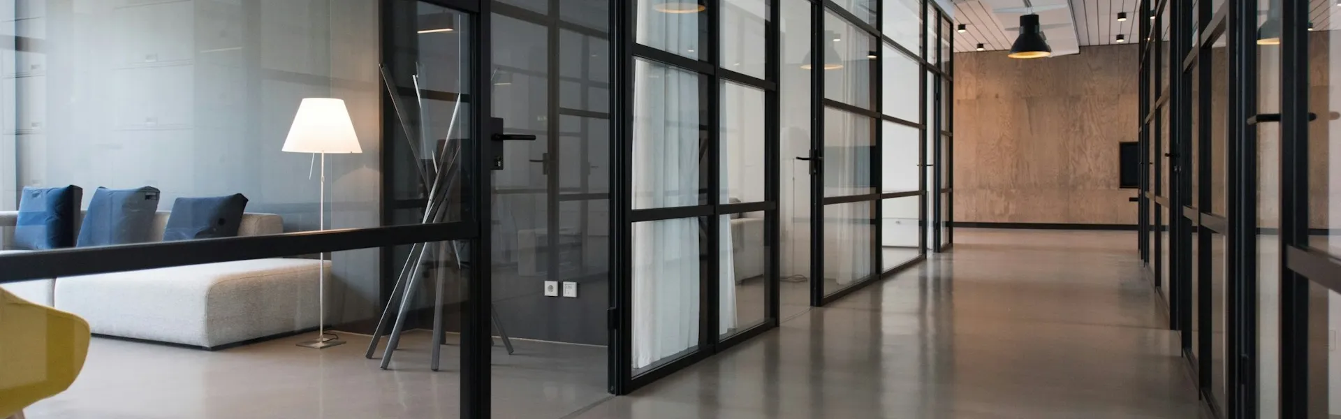 Oficina con puestos compartidos, grandes ventanas y plantas