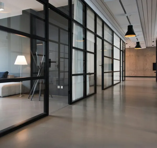 Oficina con puestos compartidos, grandes ventanas y plantas